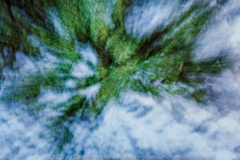 An image that makes one feel as if we're looking down through clouds to a green forest below