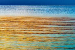 Deep blue horizon with metallic deep golden hues playing on all colors blue